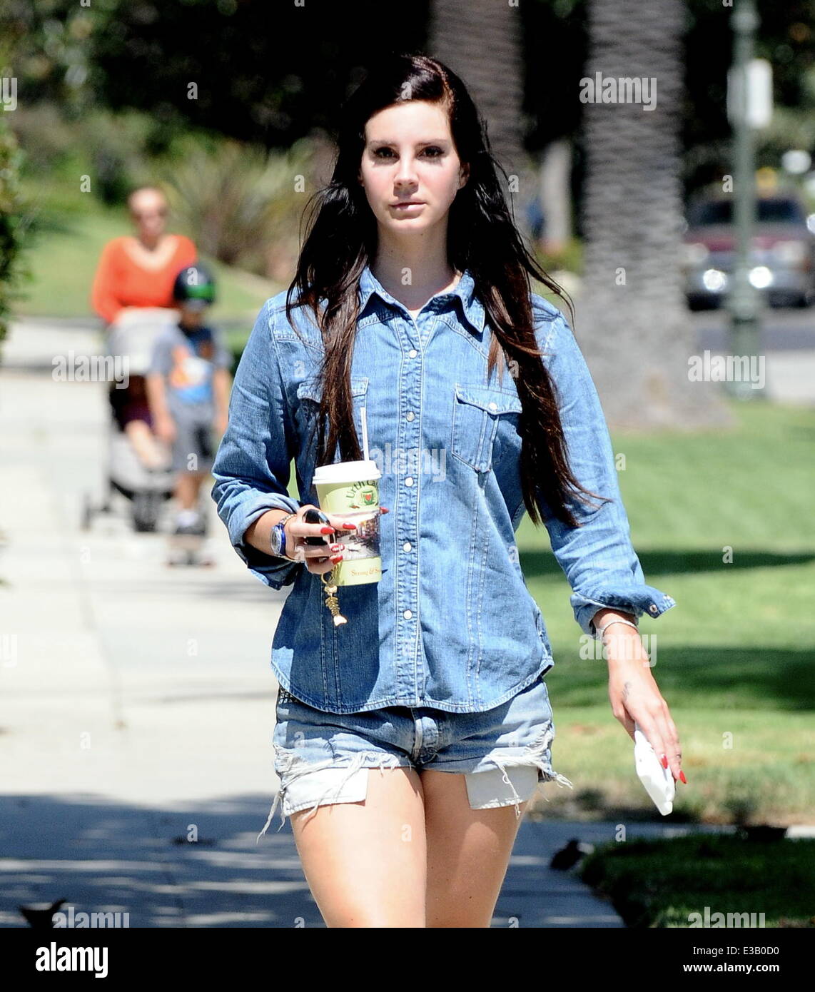 Lana Del Rey walking around Larchmont Village wearing a denim shirt and  matching Daisy Duke-style