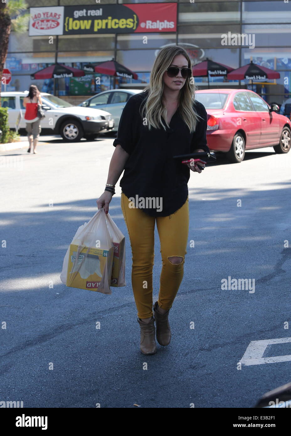 https://c8.alamy.com/comp/E3B2F1/hilary-duff-out-shopping-in-ripped-yellow-jeans-buying-glad-quick-E3B2F1.jpg