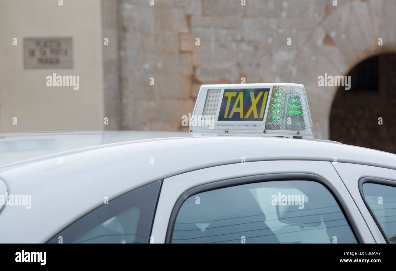 Top of free taxi with a green light in front of old building in Majorca village with portal behind Stock Photo