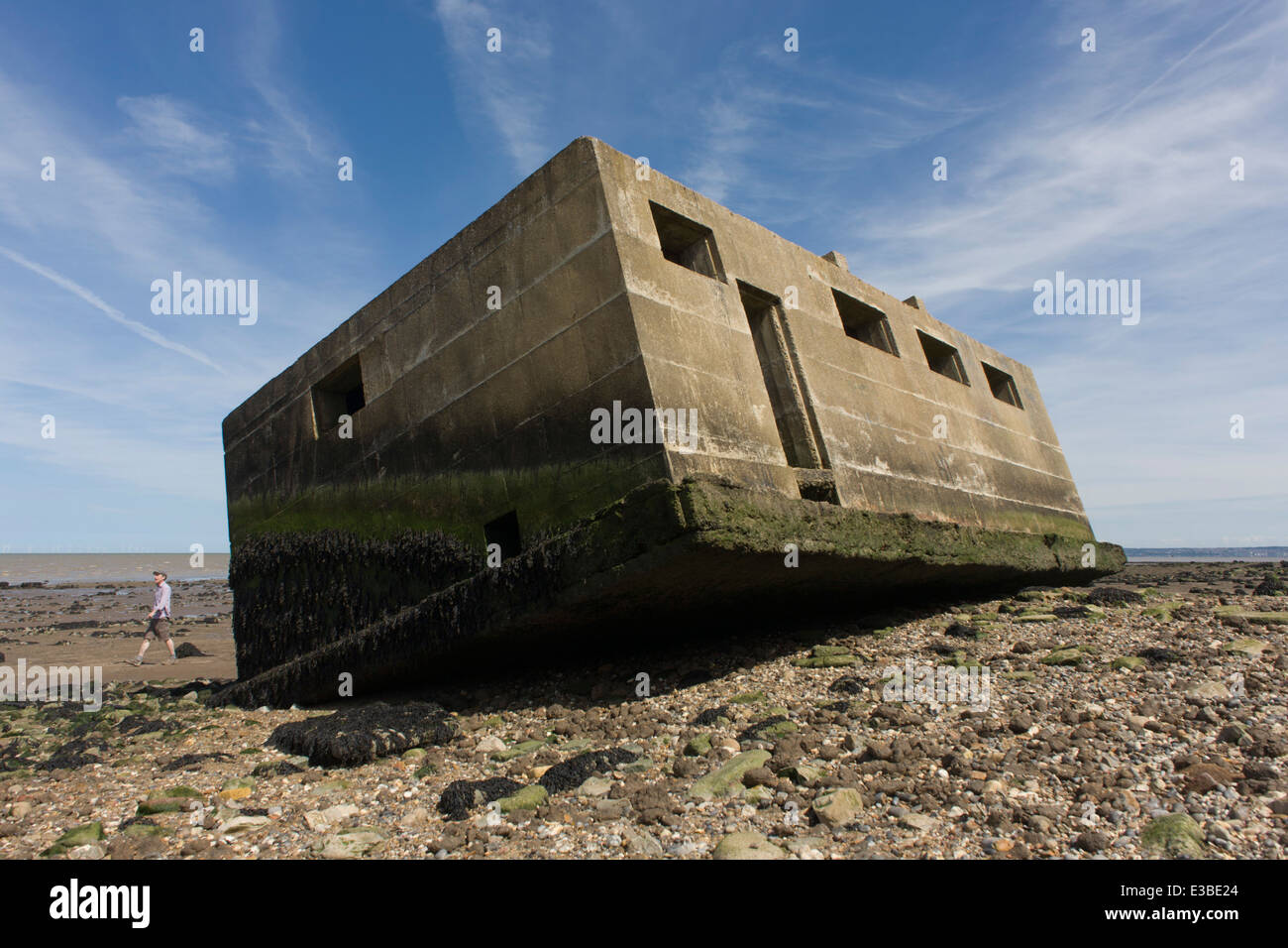 WW2era concrete pillbox defence structure lies on the beach after