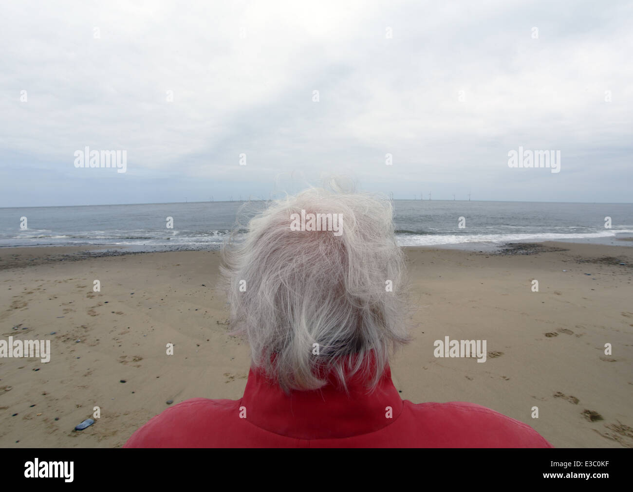 Elderly woman looking out to sea. Stock Photo