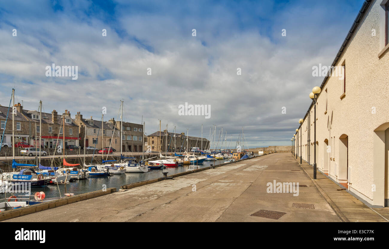 LOSSIEMOUTH HARBOUR WITH MOORED YACHTS AND RENOVATED BUILDINGS ON BOTH SIDES OF THE MARINA Stock Photo
