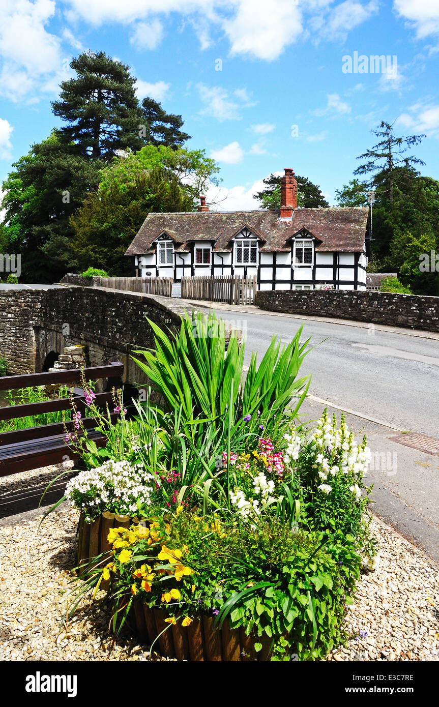 Black And White Timbered Millstream Cottage With Flowers And Bridge In ...