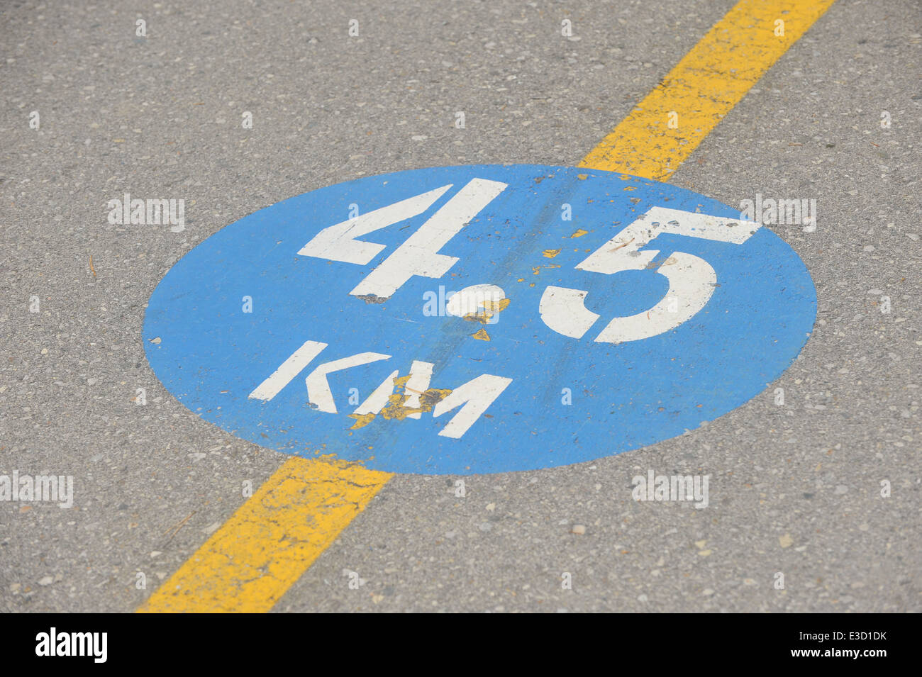 A distance marker sign painted on a cycle path in London, Ontario. Stock Photo