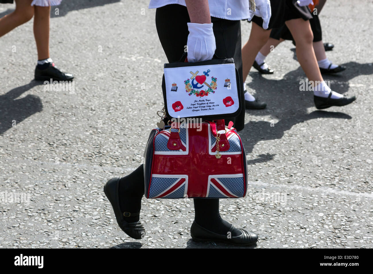 Woman carrying a Union Jack motif handbag during a Loyalist Orange Walk, Glasgow, Scotland, UK Stock Photo