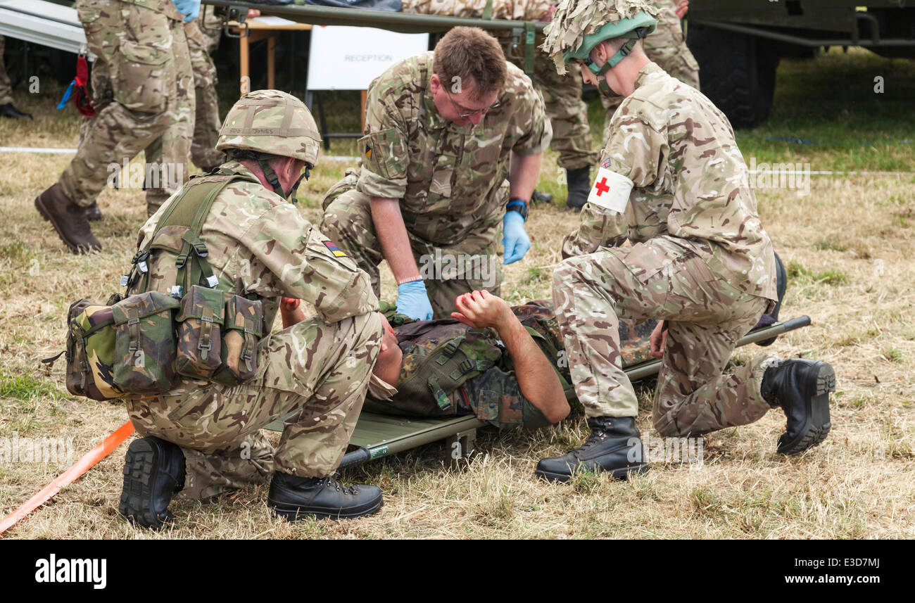 Medics givving assistance to wounded soldier on stretcher during