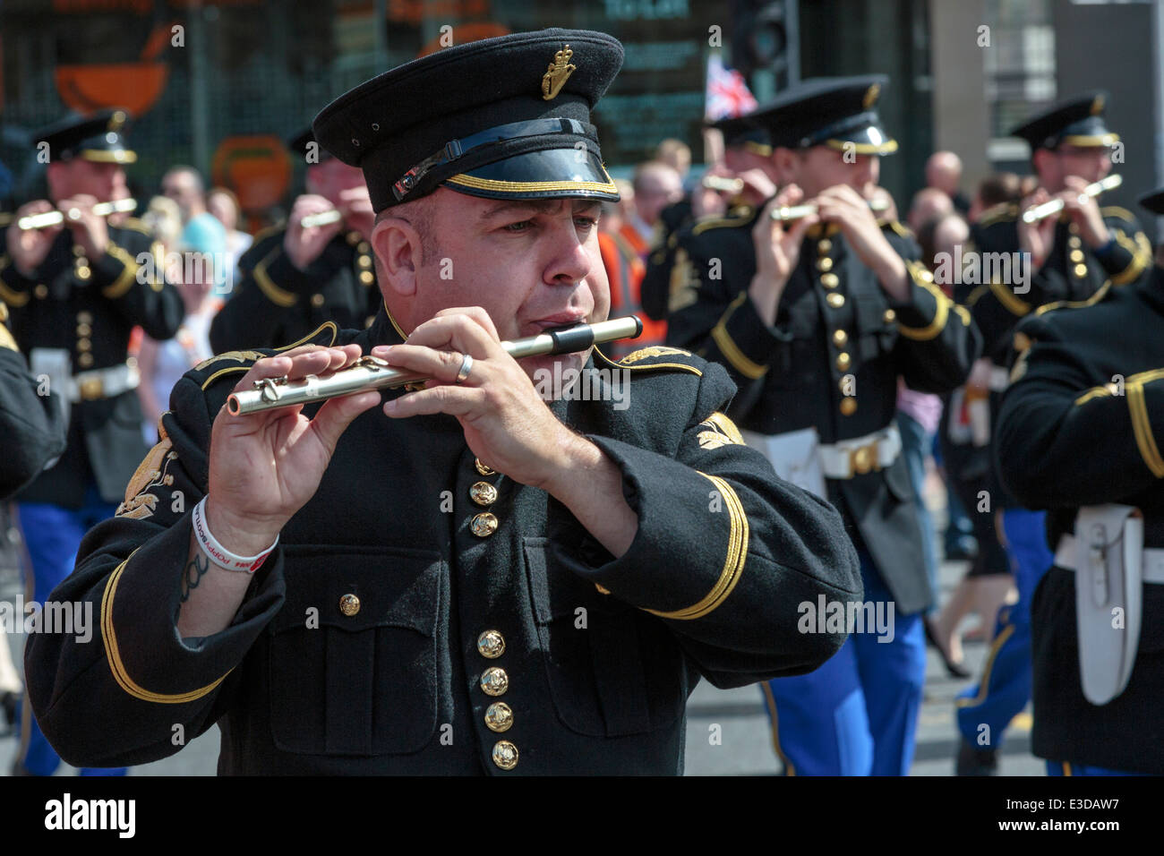 Man playing the flute, taking part in an Orange Walk parade through the