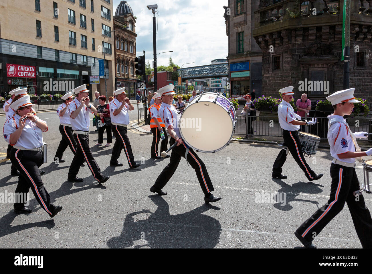 Man playing the bass drum, taking part in an Orange Walk parade through the streets of Glasgow, Scotland, UK Stock Photo