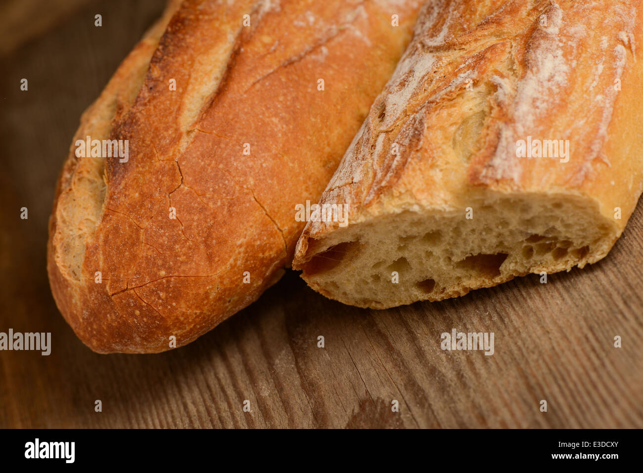 French crusty bread, isolated on a wooden plank background Stock Photo
