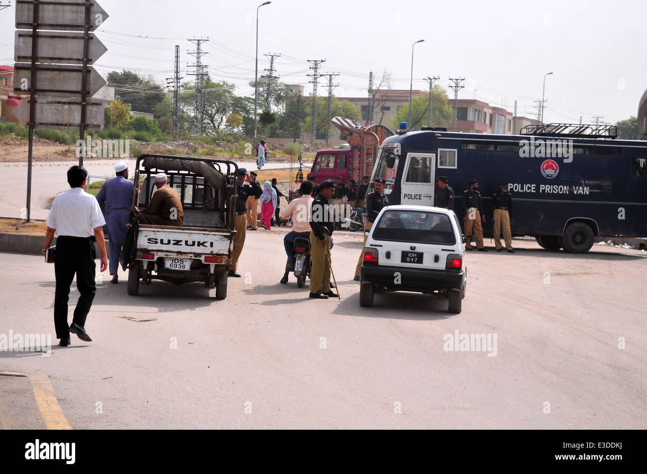 Rawalpindi, Pakistan. 23rd June, 2014. Policemen stop vehicles on the way to Benazir Bhutto International Airport in Rawalpindi, Pakistan, on June 23, 2014. Pakistani authorities on Monday denied permission to a plane carrying an anti-government religious leader to land at the Islamabad airport over security concerns.  Credit:  Ahmad Kamal/Xinhua/Alamy Live News Stock Photo