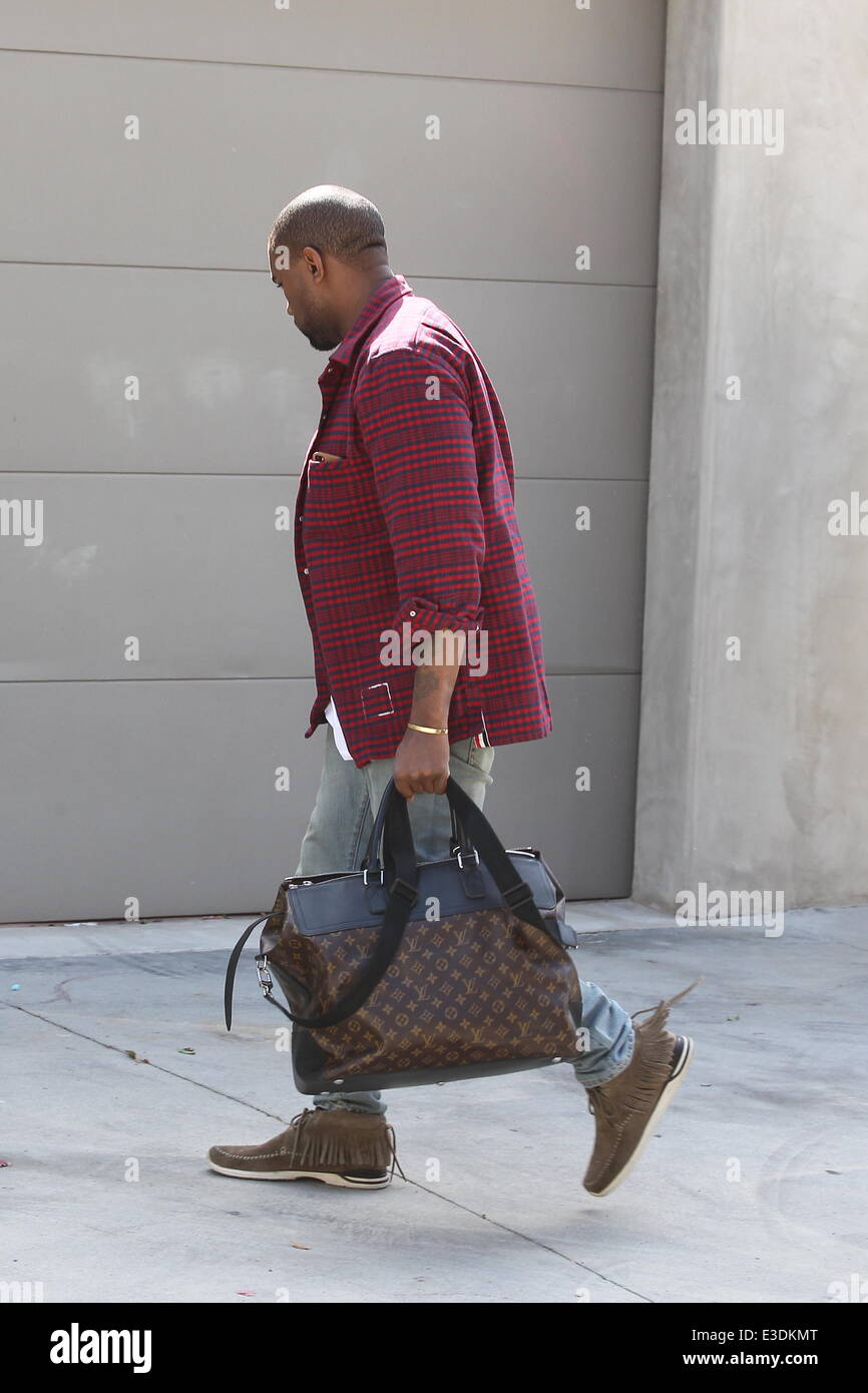 Kanye West leaving his office in a red and blue checkered jacket and  carrying a large Louis Vuitton luggage bag Featuring: Kany Stock Photo -  Alamy