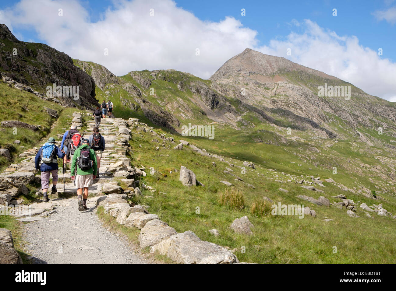 Walkers on Pyg Track walking towards Crib Goch at start of Snowdon Horseshoe in Snowdonia National Park. Pen-y-Pass Wales UK Stock Photo