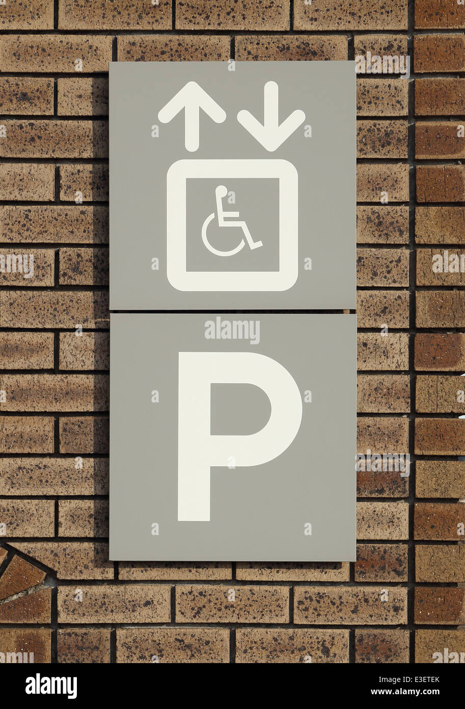 disabled parking sign on a brick wall Stock Photo