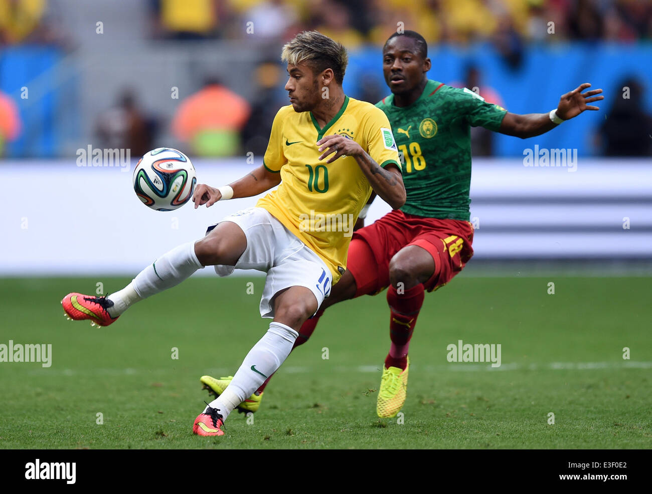Brasilia, Brazil. 23rd June, 2014. Cameroon's Eyong Enoh (R) vies for the ball with Neymar of Brazil during the FIFA World Cup 2014 group A preliminary round match between Cameroon and Brazil at the Estadio Nacional in Brasilia, Brazil, 23 June 2014. Photo: Marius Becker/dpa/Alamy Live News Stock Photo