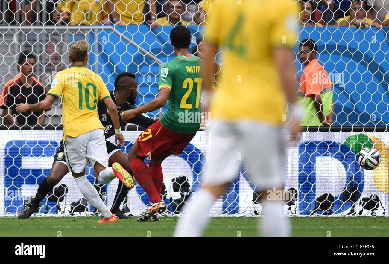 Brasilia, Brazil. 23rd June, 2014. Neymar (L) of Brazil scores against Cameroon's goal keeper Charles Itandje (2-R) during the FIFA World Cup 2014 group A preliminary round match between Cameroon and Brazil at the Estadio Nacional in Brasilia, Brazil, 23 June 2014. Photo: Marius Becker/dpa/Alamy Live News Stock Photo