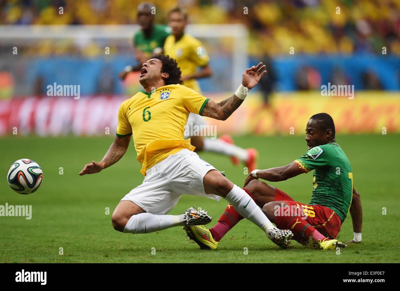 Brasilia, Brazil. 23rd June, 2014. Cameroon's Eyong Enoh (R) vies for the ball with Marcelo of Brazil during the FIFA World Cup 2014 group A preliminary round match between Cameroon and Brazil at the Estadio Nacional in Brasilia, Brazil, 23 June 2014. Photo: Marius Becker/dpa/Alamy Live News Stock Photo