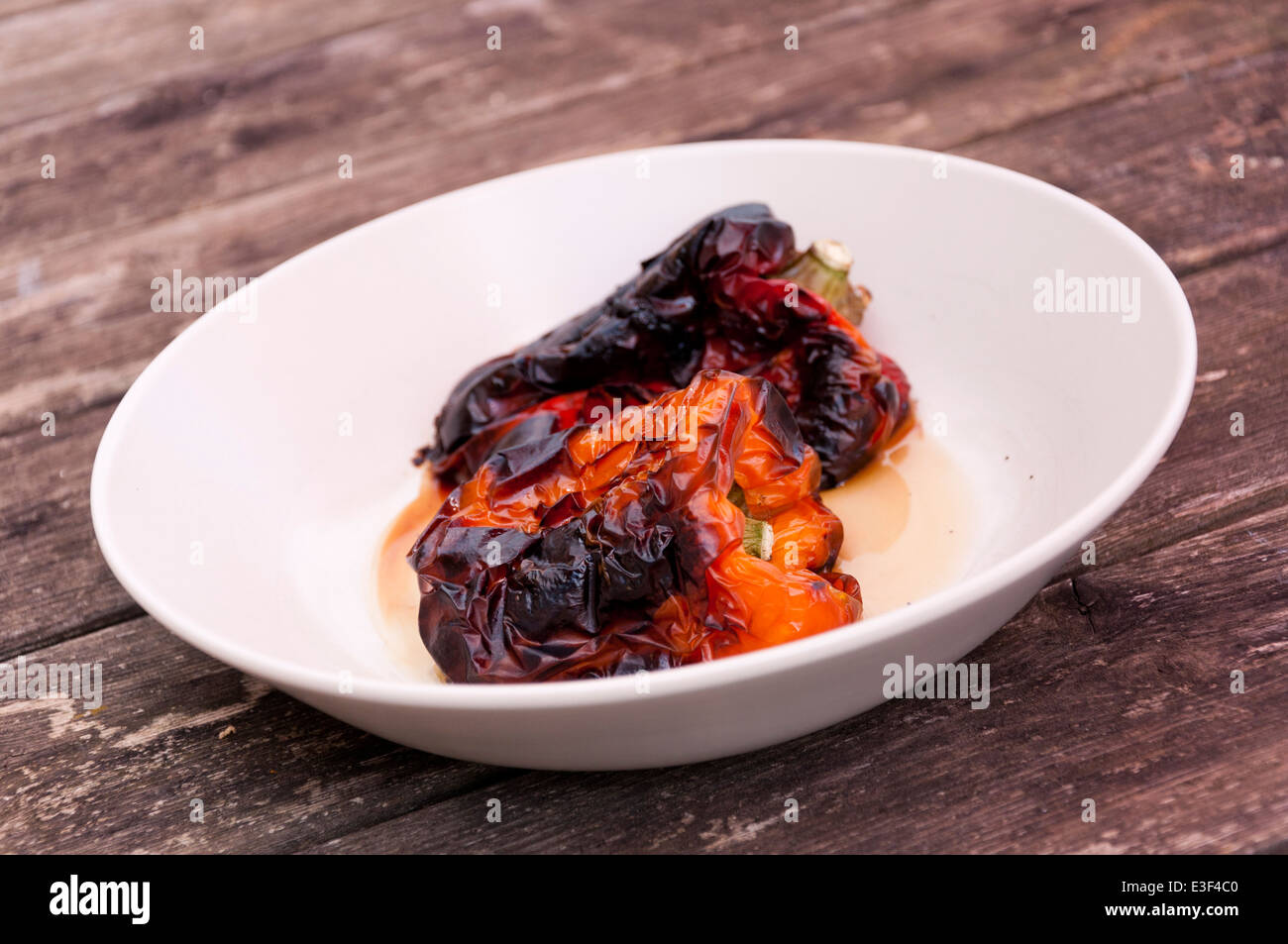 Barbecued grilled whole capsicum peppers Stock Photo