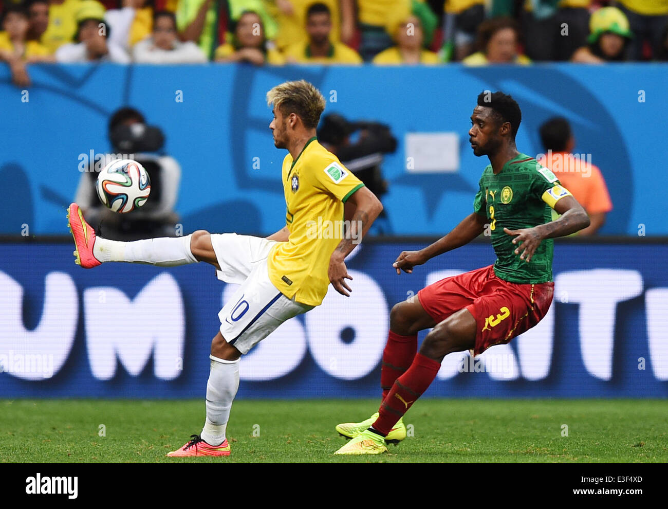 Brasilia, Brazil. 23rd June, 2014. Cameroon's Nicolas Nkoulou (R) and Brazil's Neymar vie for the ball during the FIFA World Cup 2014 group A preliminary round match between Cameroon and Brazil at the Estadio Nacional in Brasilia, Brazil, 23 June 2014. Photo: Marius Becker/dpa/Alamy Live News Stock Photo