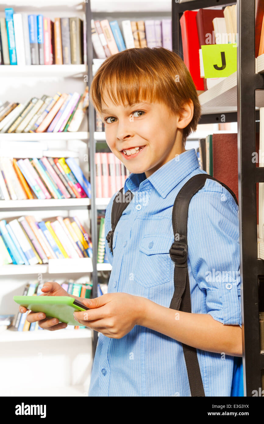 Smiling boy stands and holds books in library Stock Photo - Alamy