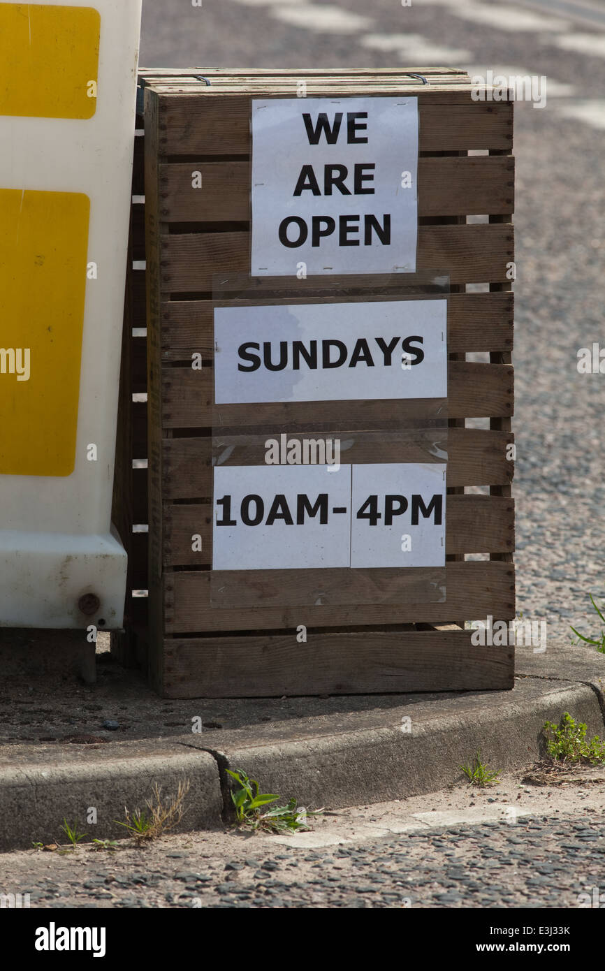 Sign out side a farm shop and garden centre. Announcing 'We are open on Sundays. 10 am - 4pm'. Change regarding sales Sundays Stock Photo