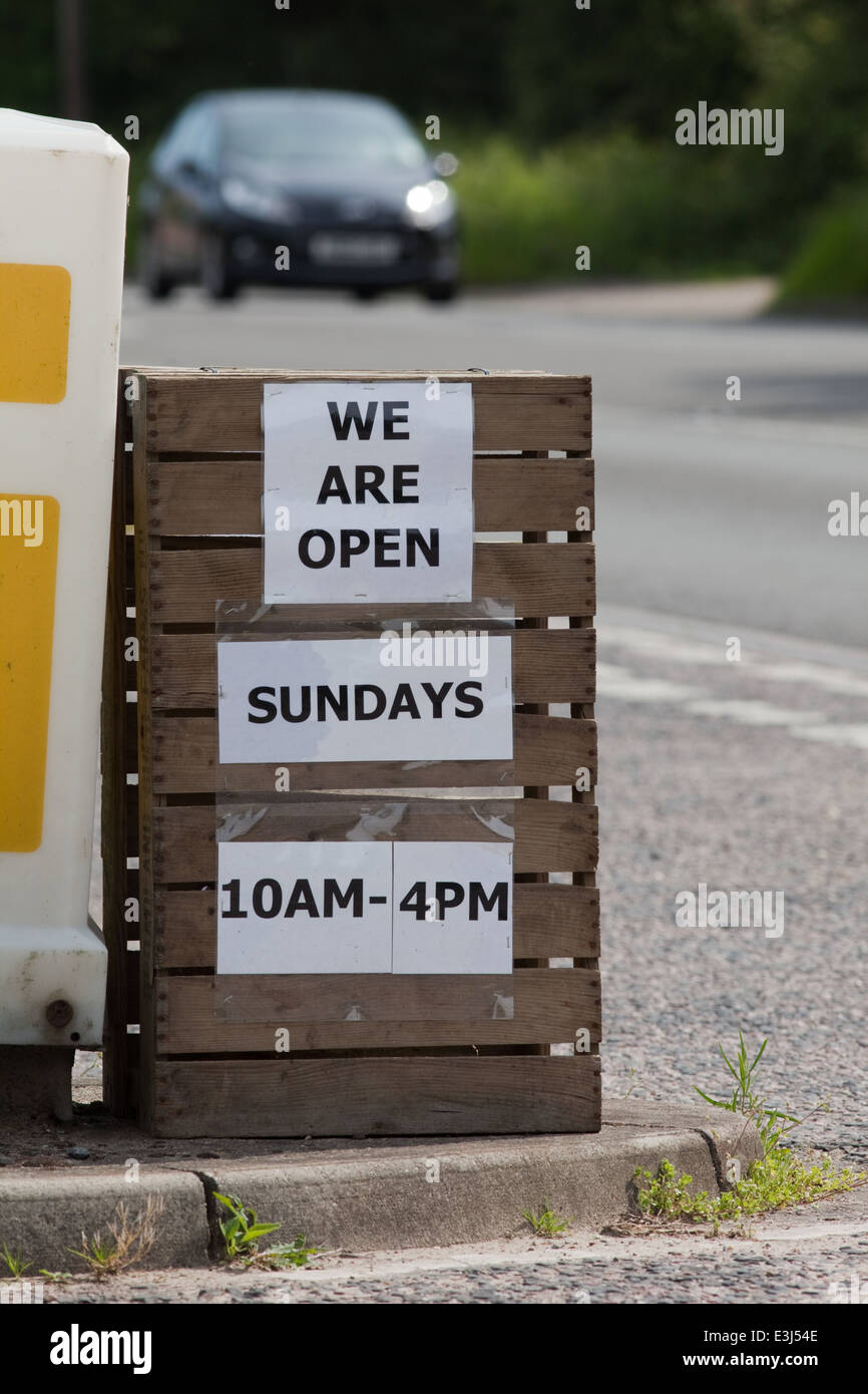 Sign out side a farm shop and garden centre. Announcing 'We are open on Sundays. 10 am - 4pm'. Change regarding sales Sundays Stock Photo