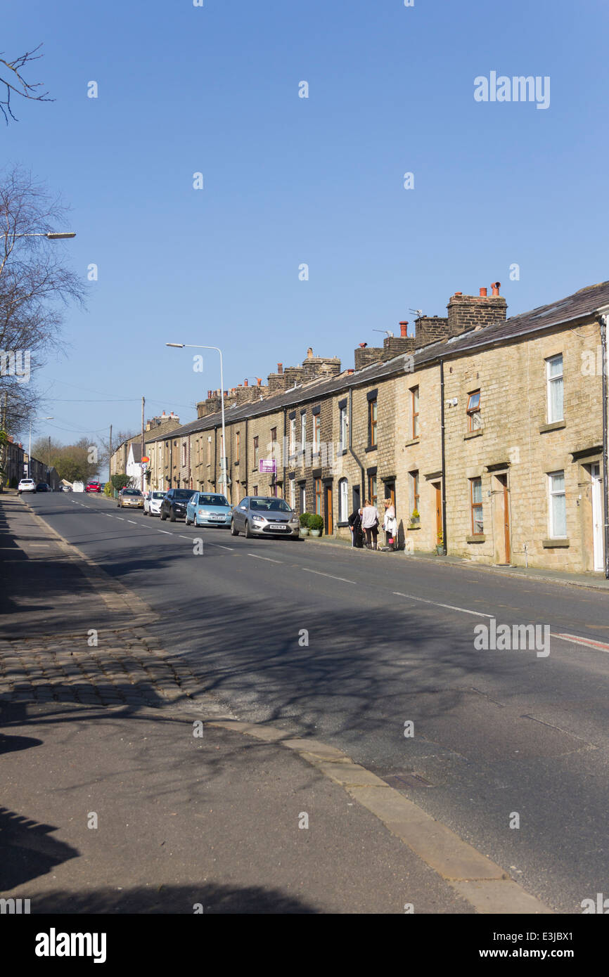 Three women chat outside cottages on High Street, Belmont, Lancashire