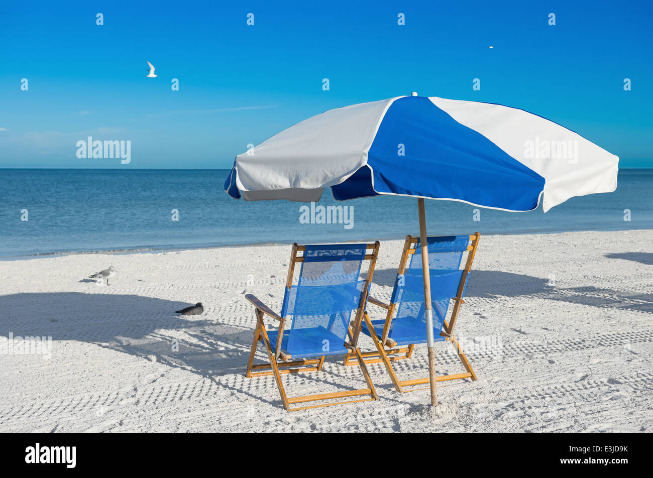 sun loungers and a beach umbrella on silver sand, vacation concept Stock Photo