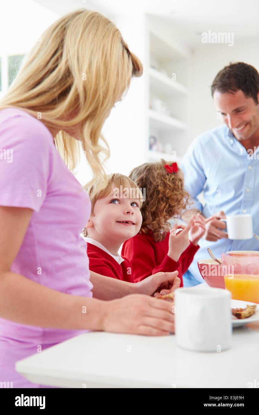 Family Having Breakfast In Kitchen Before School Stock Photo