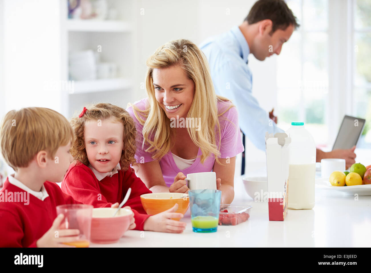 Family Having Breakfast In Kitchen Before School And Work Stock Photo