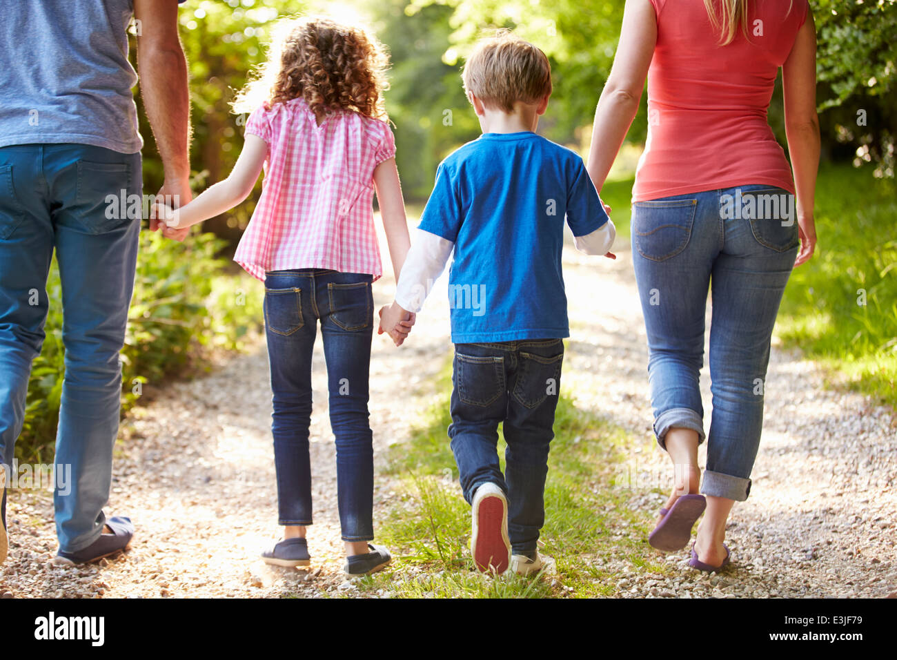 Rear View Of Family Walking In Countryside Stock Photo