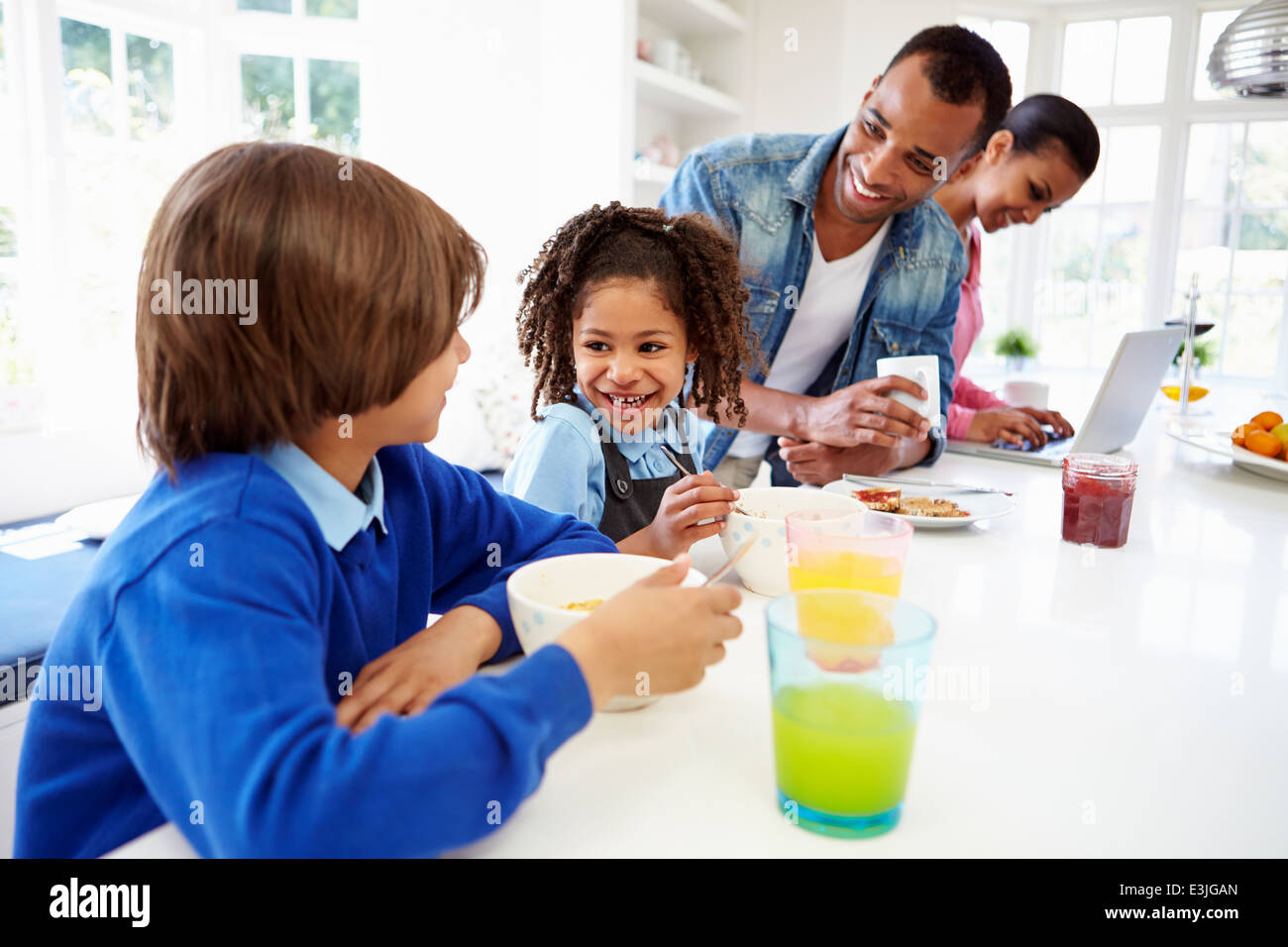 Family Having Breakfast In Kitchen Before School Stock Photo