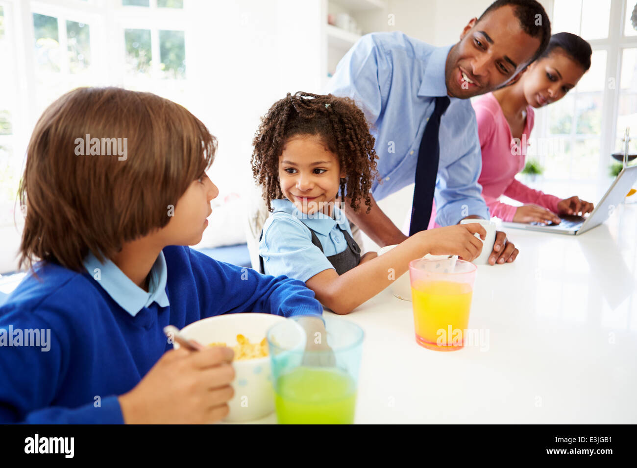 Family Having Breakfast In Kitchen Before School And Work Stock Photo
