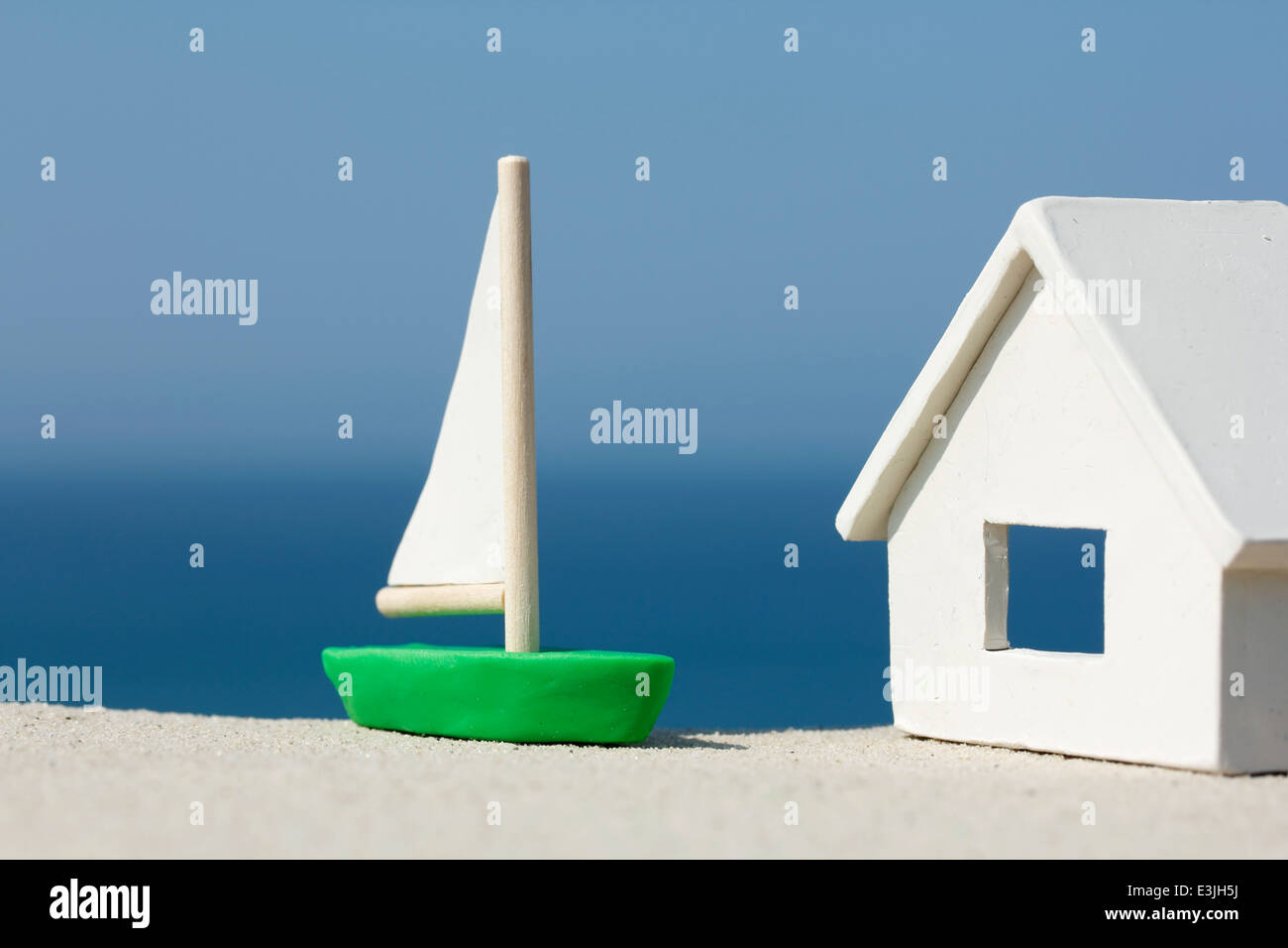 Model House and Boat by the Ocean Stock Photo