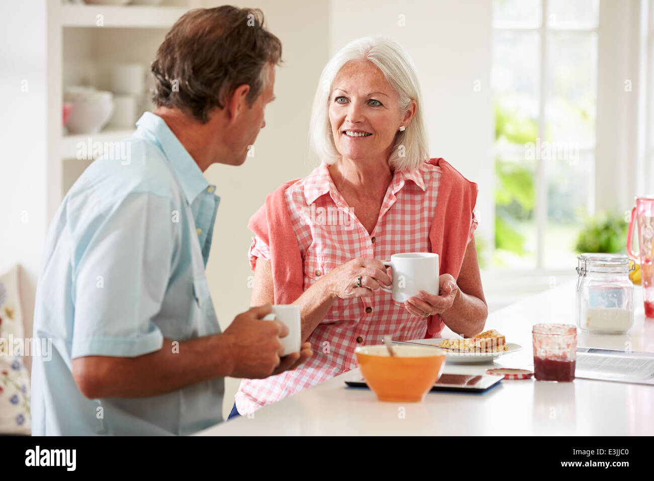 Middle Aged Couple Enjoying Breakfast At Home Together Stock Photo