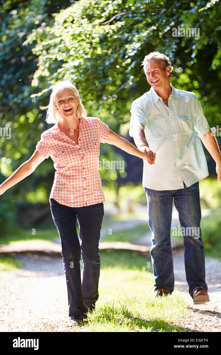 Romantic Middle Aged Couple Walking Along Countryside Path Stock Photo