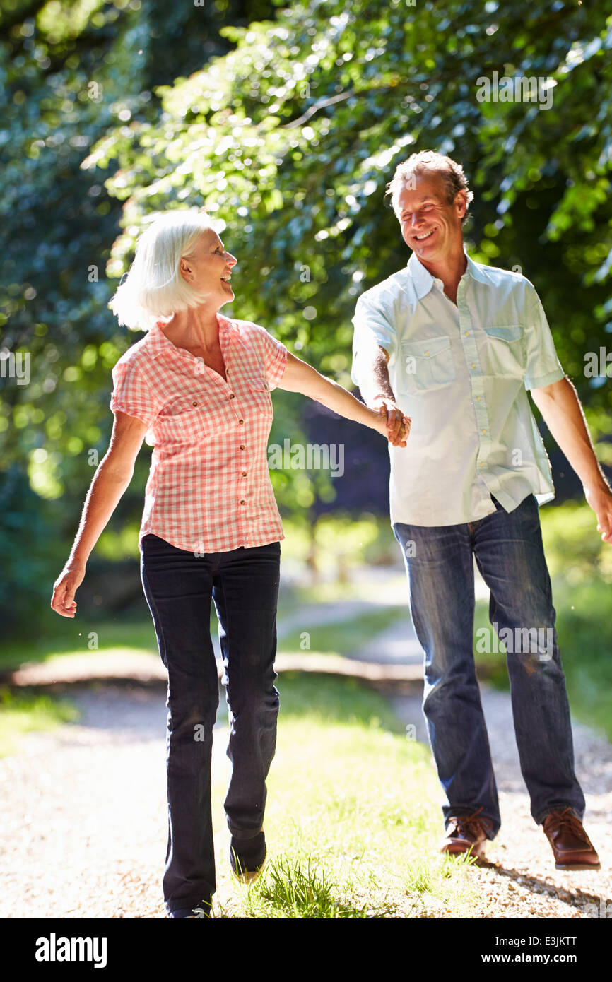 Romantic Middle Aged Couple Walking Along Countryside Path Stock Photo