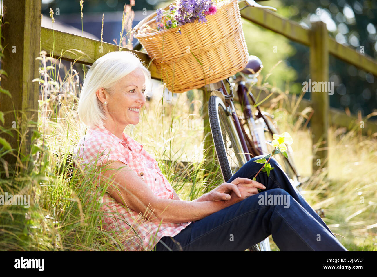 Middle Aged Woman Relaxing On Country Cycle Ride Stock Photo