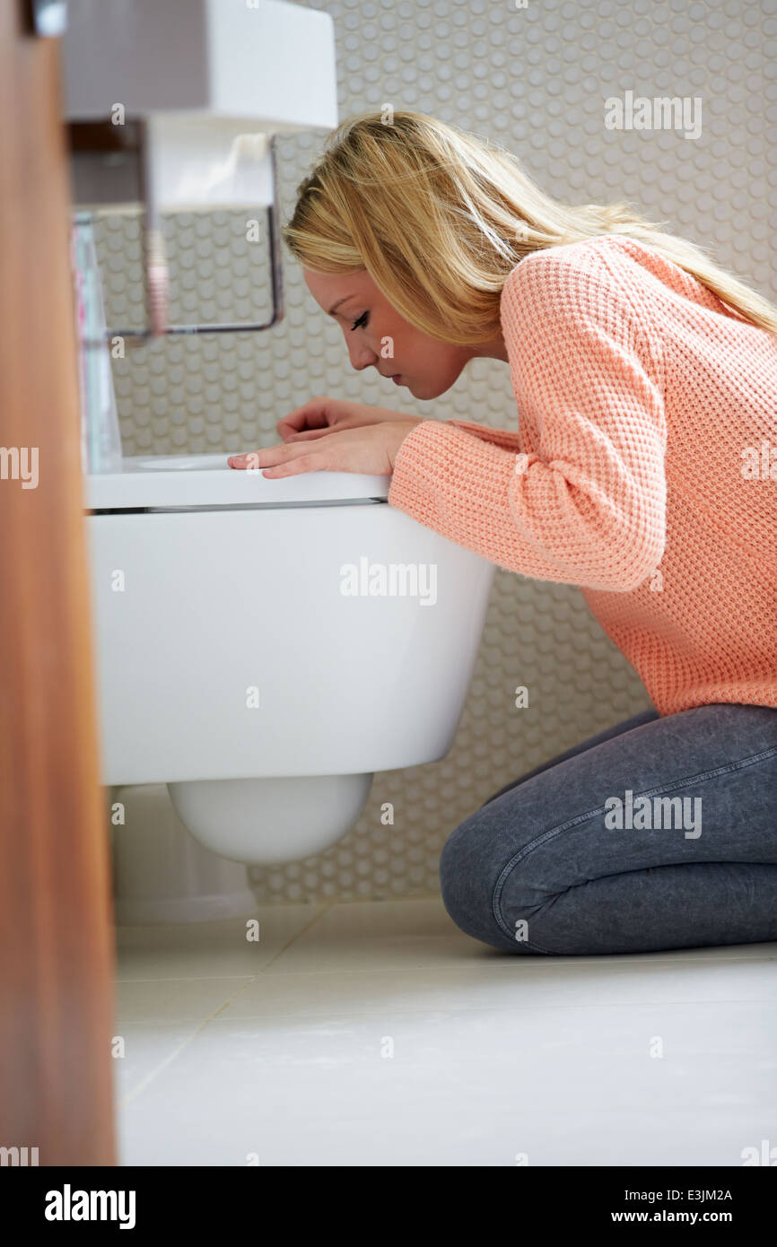 Teenage Girl Feeling Unwell In Bathroom Stock Photo