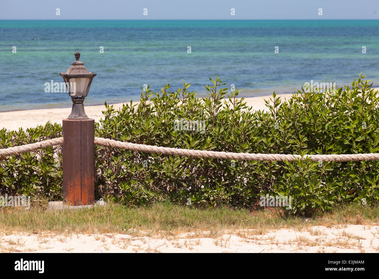 Beach border railing with rope and light Stock Photo