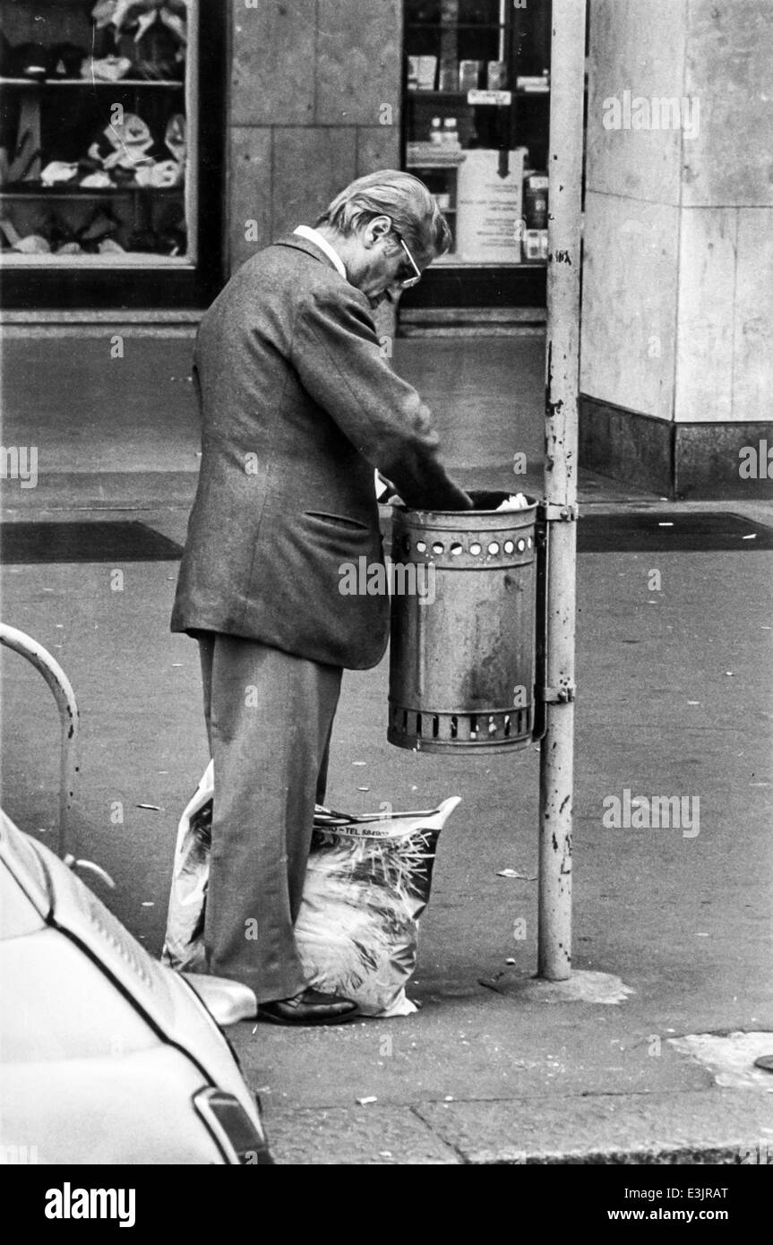 elderly man looking in a trashcan,near central station in milan,italy Stock Photo