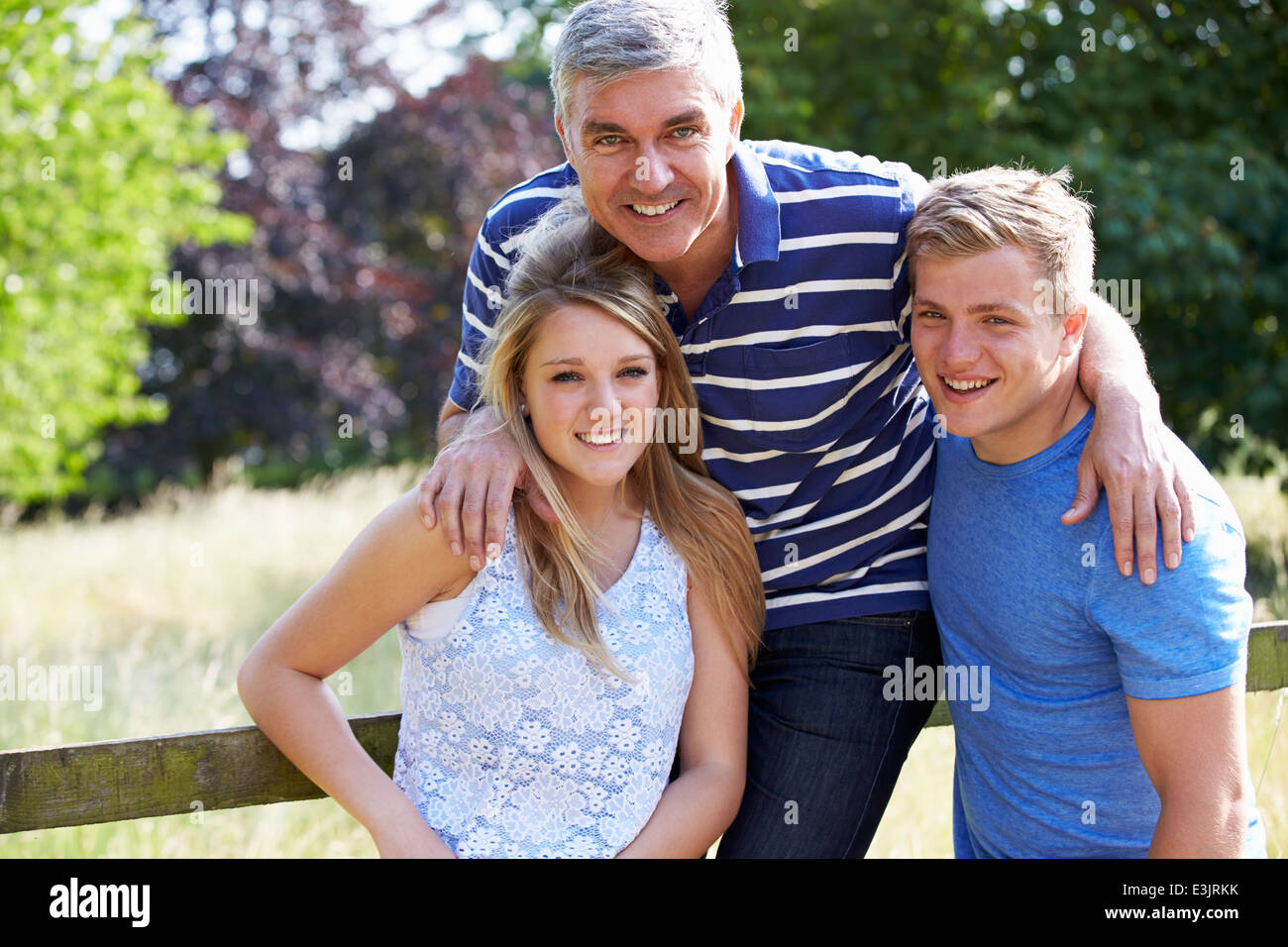 Father With Teenage Children Walking In Countryside Stock Photo
