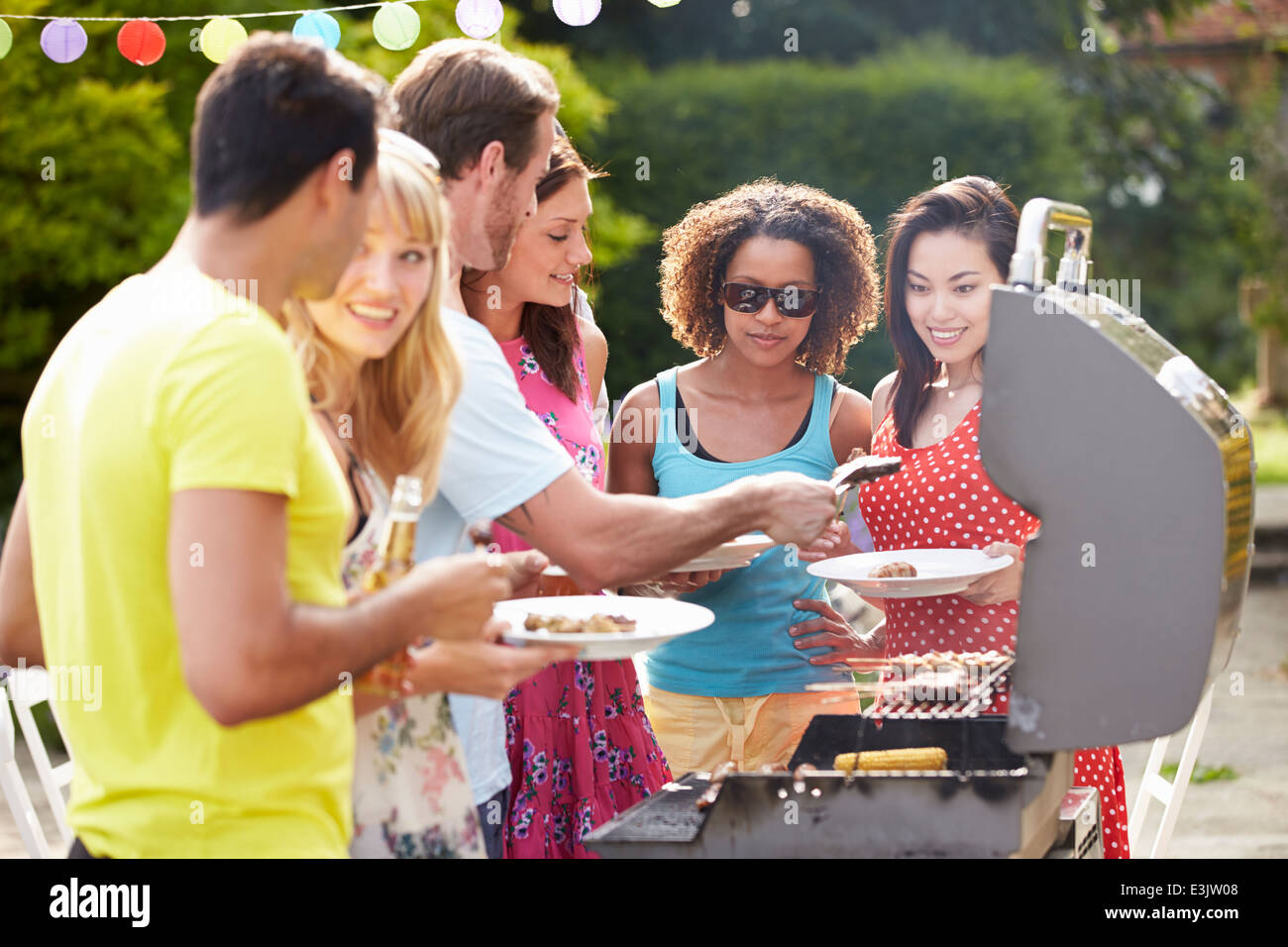 Group Of Friends Having Outdoor Barbeque At Home Stock Photo