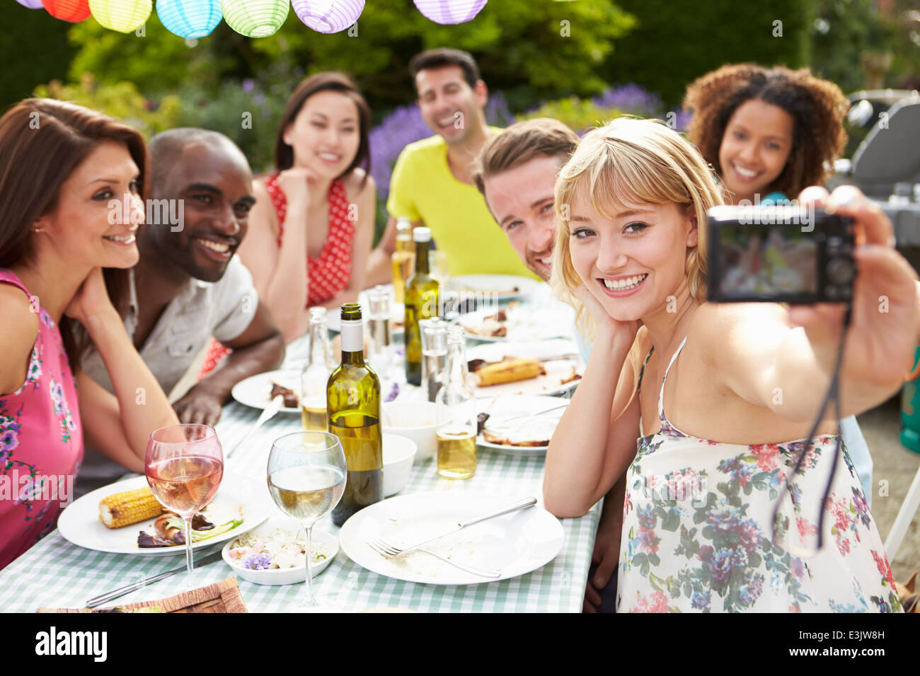 Friends Taking Self Portrait On Camera At Outdoor Barbeque Stock Photo