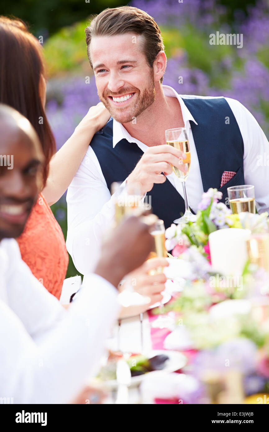 Group Of Friends Enjoying Outdoor Dinner Party Stock Photo