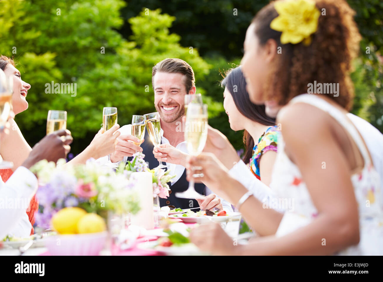 Group Of Friends Enjoying Outdoor Dinner Party Stock Photo