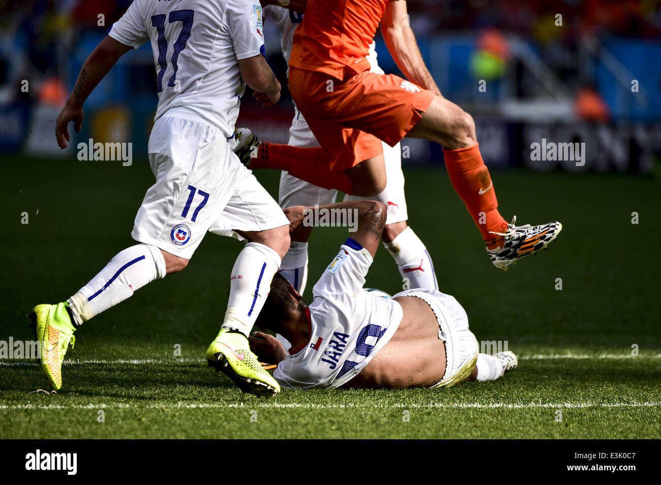 Sao Paolo, Brazil. 23rd June, 2014. Arjen Robben jumps over Gonzalo Jara (18) sliding to take out the ball at the match #36 of the 2014 World Cup, between Netherlands and Chile, this monday, June 23rd, in Sao Paulo, Brasil Credit:  Gustavo Basso/NurPhoto/ZUMAPRESS.com/Alamy Live News Stock Photo