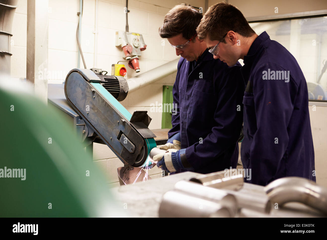 Engineer Teaching Apprentice To Use Grinding Machine Stock Photo