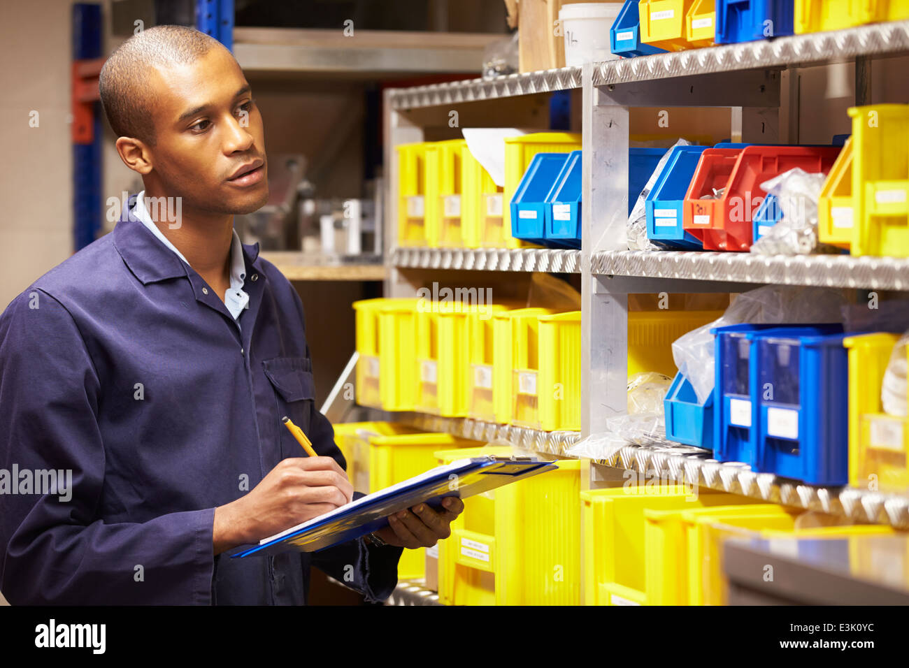 Worker Checking Stock Levels In Store Room Stock Photo