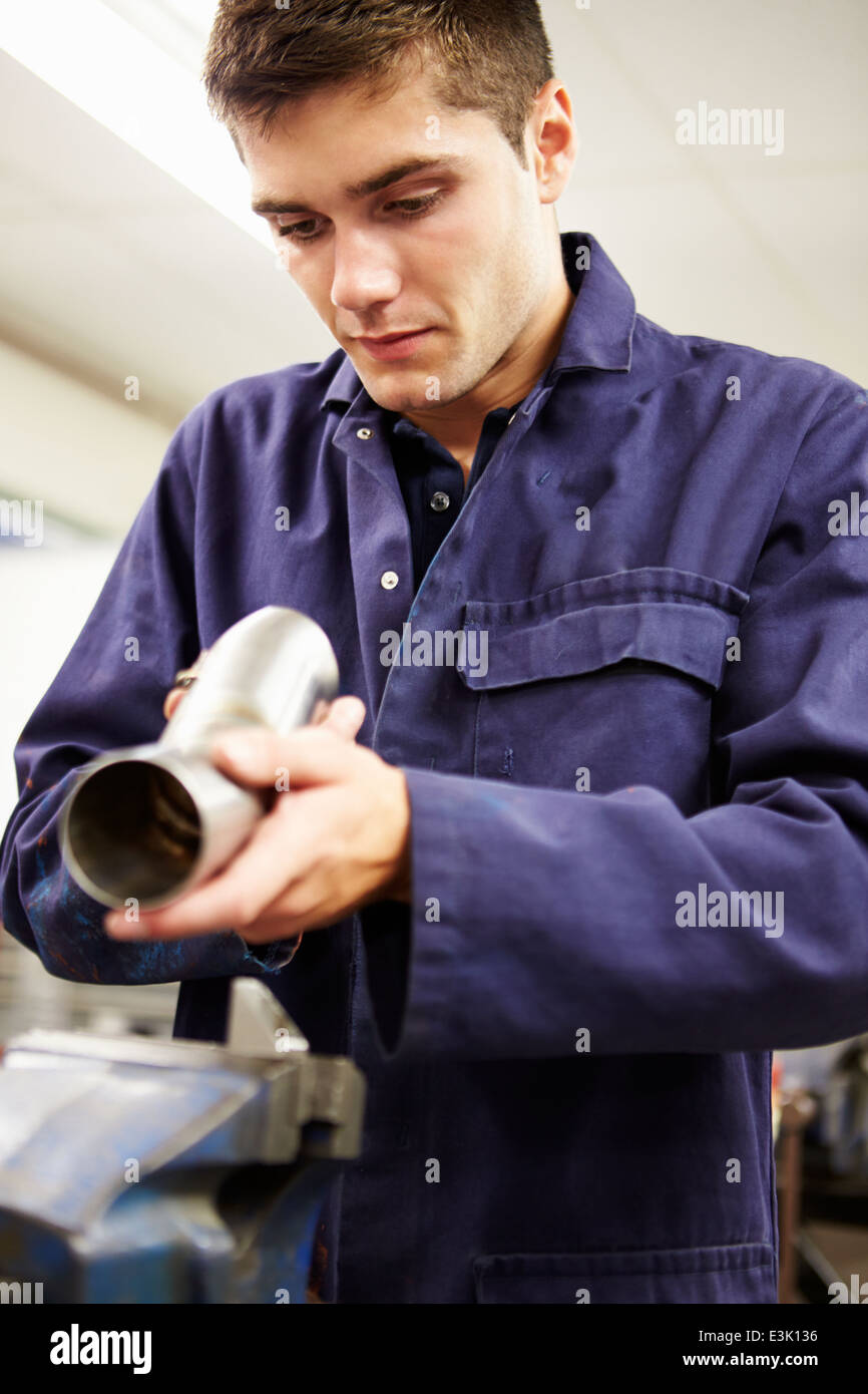 Apprentice Engineer Checking Component On Factory Floor Stock Photo