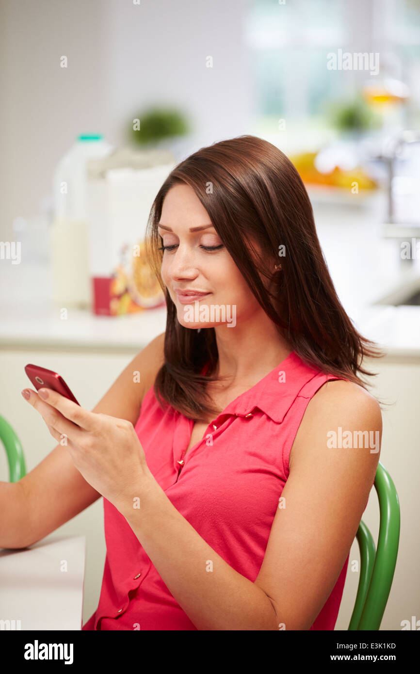 Hispanic Woman Sending Text Message At Home Stock Photo